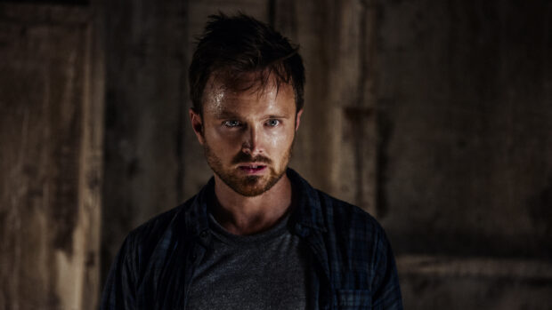 Aaron Paul appears focused and intense in a dark setting with a serious expression, 2K Desktop Wallpaper