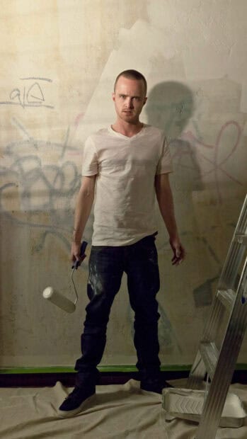 Aaron Paul is holding a paint roller while standing in front of a graffiti wall, HD Phone Wallpaper