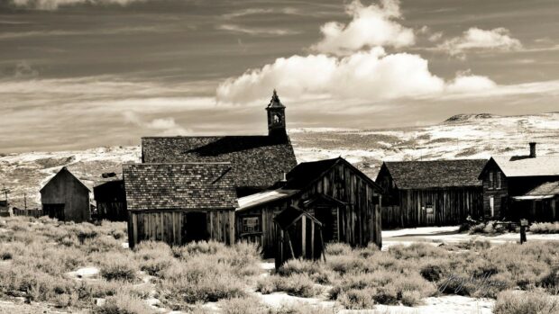 A peaceful ghost town with old wooden buildings under a cloudy sky, HD Desktop Wallpaper
