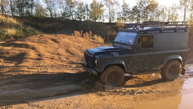 An off road driving vehicle is navigating muddy terrain during an outdoor adventure, HD Desktop Wallpaper