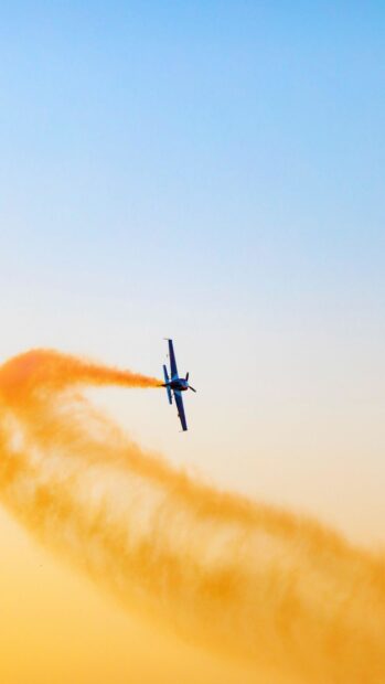 An aircraft is performing aerobatic maneuvers with orange smoke trailing, HD Phone Wallpaper