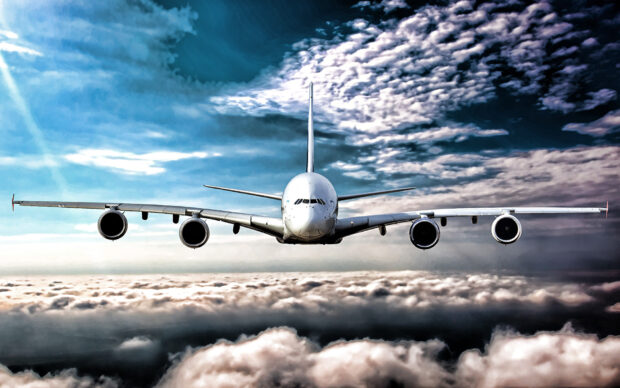 An Airbus A380 is soaring through the sky above thick clouds with the sun shining, HD Desktop Wallpaper