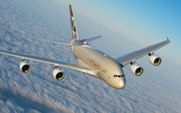 An Airbus A380 airplane soars high above the clouds during a clear day flight, 2K Desktop Wallpaper