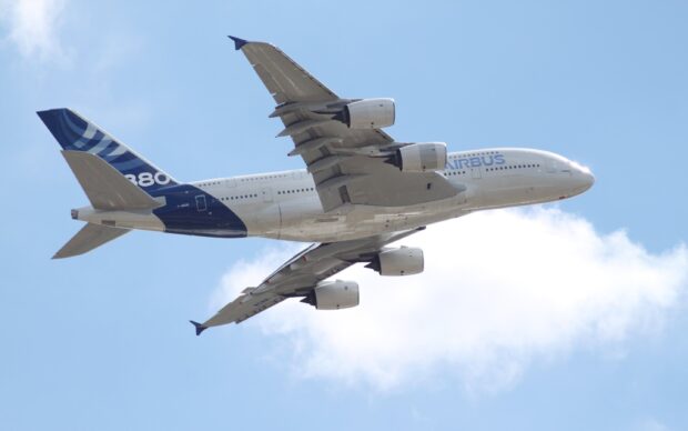 Airbus A380 is flying against a clear blue sky with white clouds, 2K Desktop Wallpaper