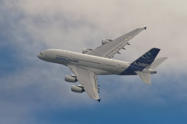 An Airbus A380 is flying through a partly cloudy sky, 2K Desktop Wallpaper