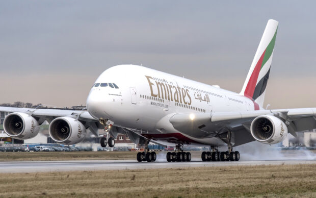 An Emirates Airbus A380 is touching down on a runway with smoke from the tires, 2K Desktop Wallpaper