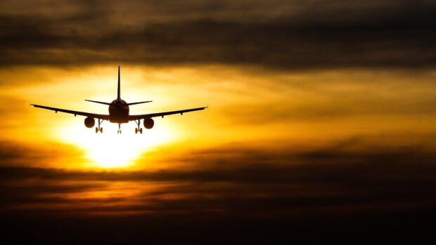 An aircraft flies towards the sunset creating a dramatic silhouette in the sky, HD Desktop Wallpaper