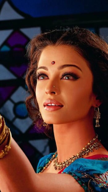 Aishwarya Rai is wearing ornate jewelry and a vibrant outfit with a focused expression, HD Mobile Wallpaper