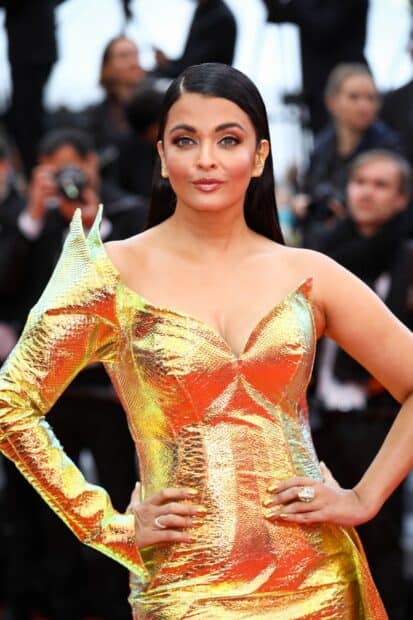 Aishwarya Rai poses confidently in a metallic gold dress at a gala event, HD Phone Wallpaper
