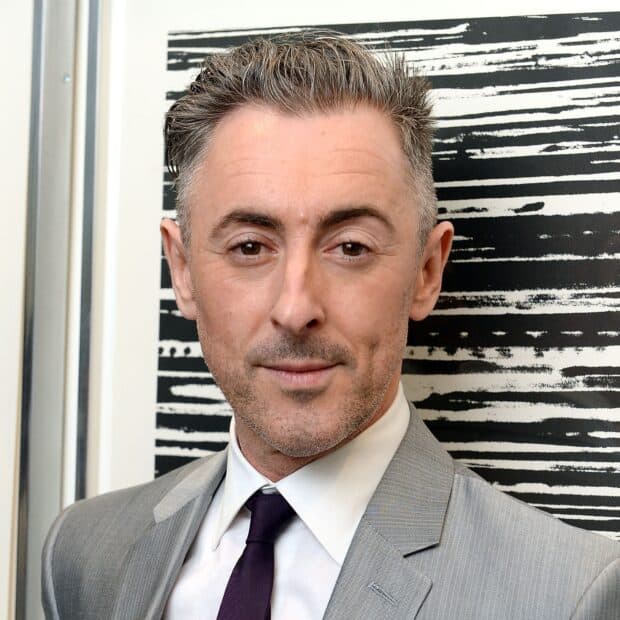 Alan Cumming wallpapers shows him in a gray suit and tie with a patterned background, HD Desktop Wallpaper