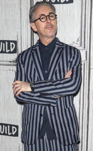 Alan Cumming is wearing a striped suit and glasses posing with arms crossed, 2K PC Wallpaper
