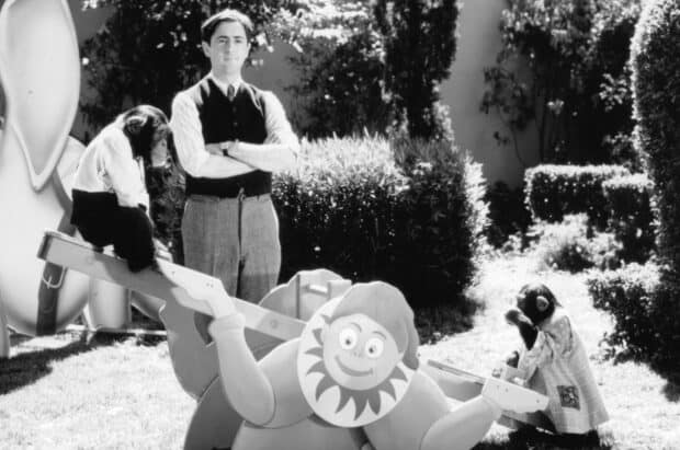 Alan Cumming is standing by a seesaw with monkeys in a black and white garden, HD Desktop Wallpaper