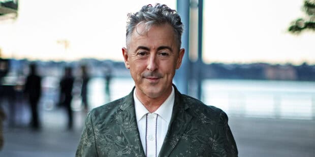 Alan Cumming stands outdoors wearing a patterned jacket and white shirt, HD Desktop Wallpaper
