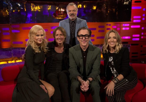 Alan Cumming and guests sitting on a red couch during a television show, 2K Desktop Wallpaper