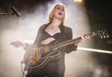 Alana Haim is performing on stage playing guitar during a live concert, HD Desktop Wallpaper
