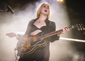 Alana Haim is performing on stage playing guitar during a live concert, HD Desktop Wallpaper
