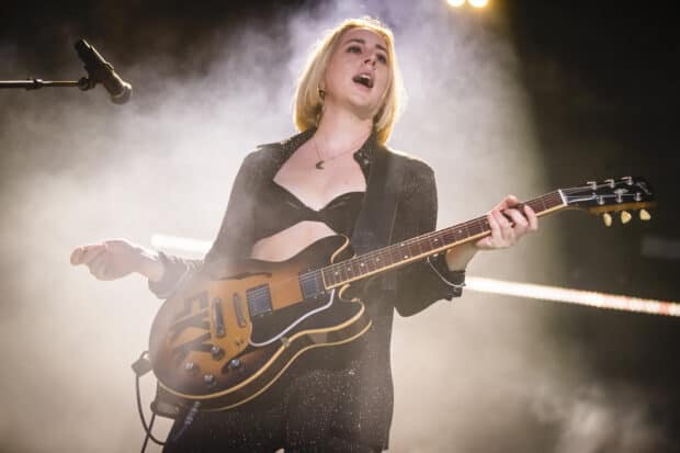 Alana Haim is performing on stage playing guitar during a live concert, HD Desktop Wallpaper