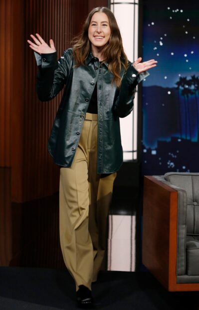 Alana Haim is smiling and waving on the stage wearing casual clothing, 2K Desktop Wallpaper