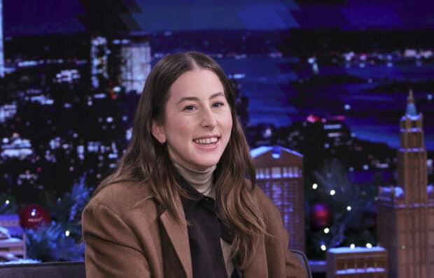 Alana Haim is seen smiling during a nighttime studio interview with cityscape decorations, HD Desktop Wallpaper