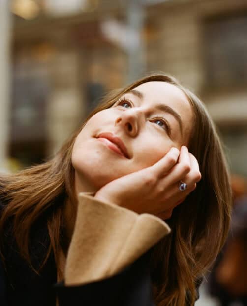 A close up of Alana Haim looking upward thoughtfully in a cozy setting, HD Phone Wallpaper