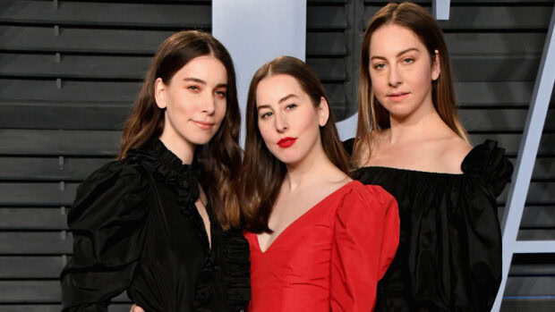 Alana Haim and her sisters posing at an event in stylish outfits, HD Desktop Wallpaper