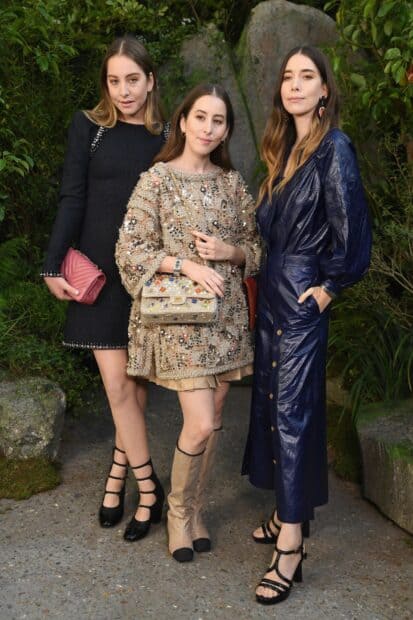 Alana Haim with her sisters posing together outdoors in fashionable dresses, HD Mobile Wallpaper