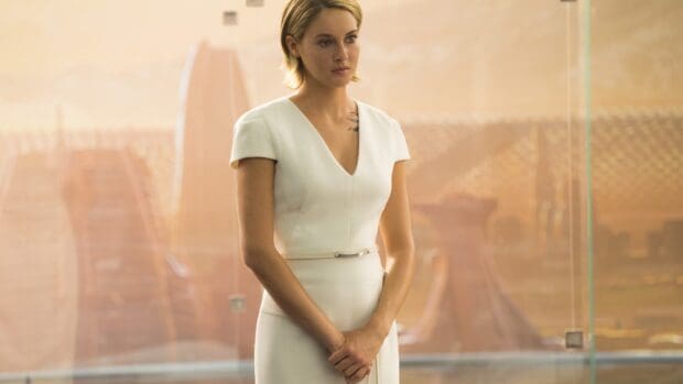 A contemplative woman stands with a solemn expression in a softly lit setting from Allegiant Wallpapers, 4K Desktop Wallpaper