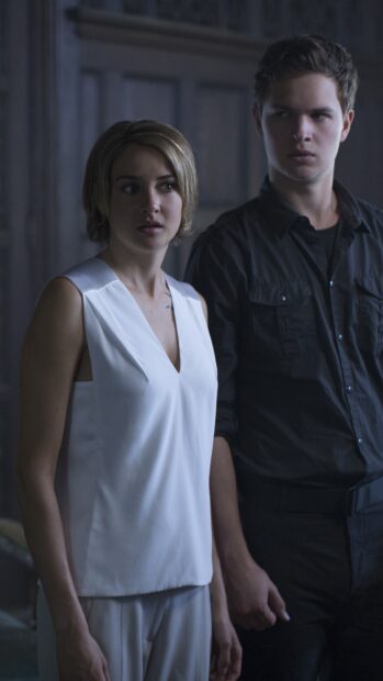 A man and woman are standing close together in a dark room showing tension in Allegiant Wallpapers, 4K Mobile Wallpaper
