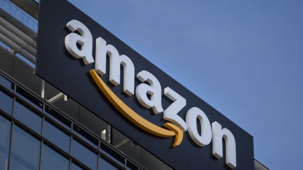 Amazon Wallpapers displayed on a building under a clear sky, HD Desktop Wallpaper