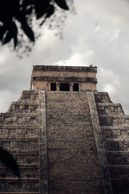 The Chichen Itza pyramid stands tall under a cloudy sky surrounded by nature, HD Mobile Wallpaper