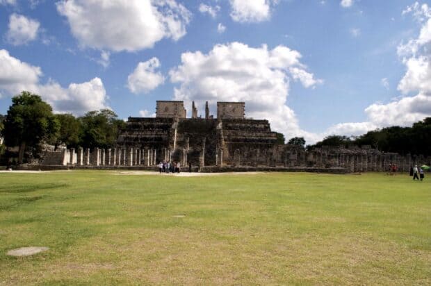 The Chichen Itza ruins stand under a partly cloudy sky with green grass in front, HD Desktop Wallpaper