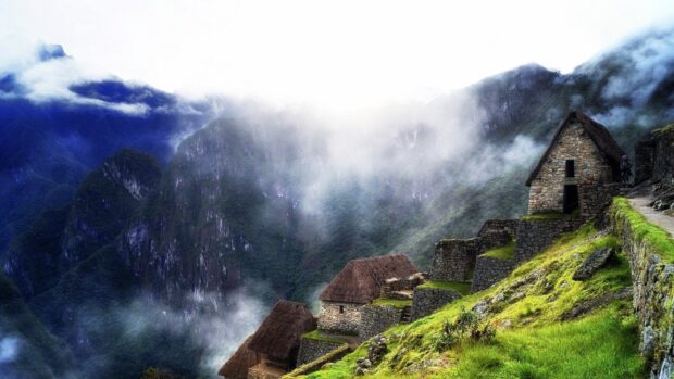 The Peru ruins stand on a misty mountain slope with stone houses and green terraces, HD Desktop Wallpaper
