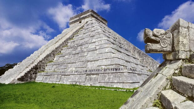 The ancient Mayan pyramid at Chichen Itza stands under a clear blue sky with green grass below, HD Desktop Wallpaper