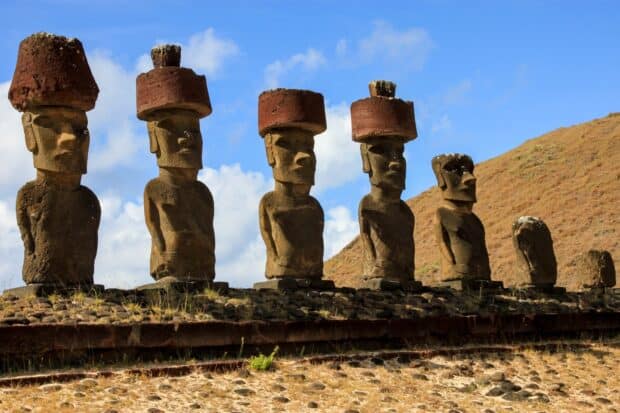 The Easter Island statues stand tall against a blue sky with grassy hills behind them, HD Desktop Wallpaper