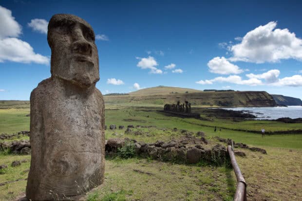 The Easter Island statues stand tall overlooking the ocean and green fields under a blue sky, HD Desktop Wallpaper