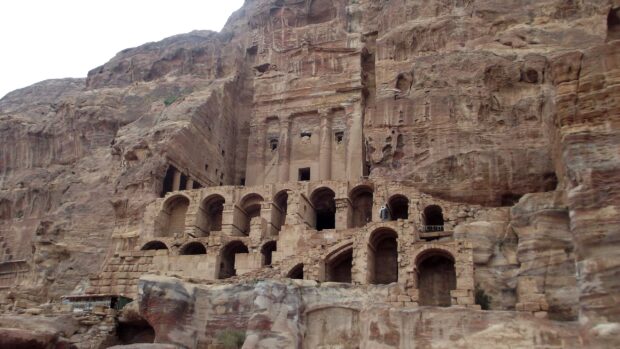 This image shows the ancient carved structures of Petra Jordan with detailed stone arches and facades, 2K Desktop Wallpaper