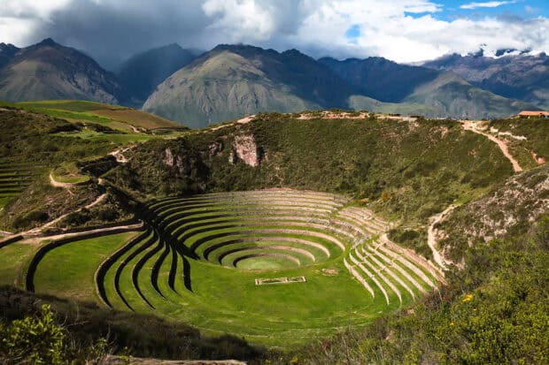 The ancient circular terraces in Peru are set against mountain views under dramatic skies, HD Desktop Wallpaper