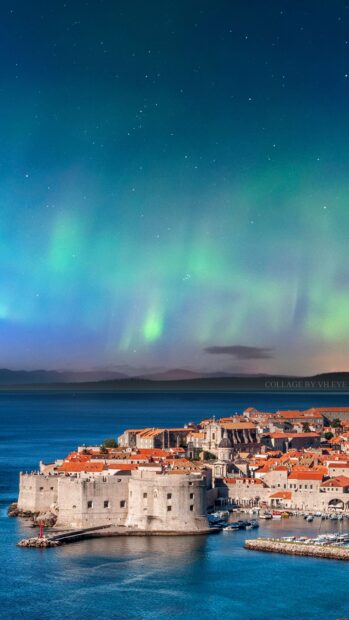 The ancient city walls in Dubrovnik stand along the coastline under a sky with northern lights, 4K Mobile Wallpaper