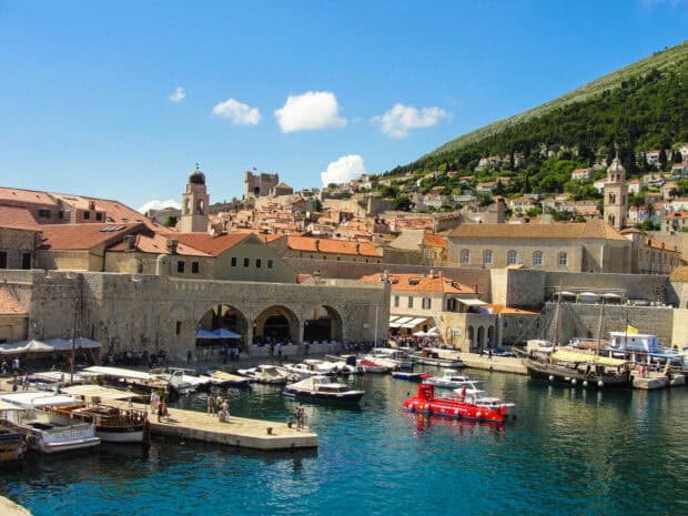 A bright sunny day shows ancient city walls and boats in Dubrovnik harbor, HD Desktop Wallpaper