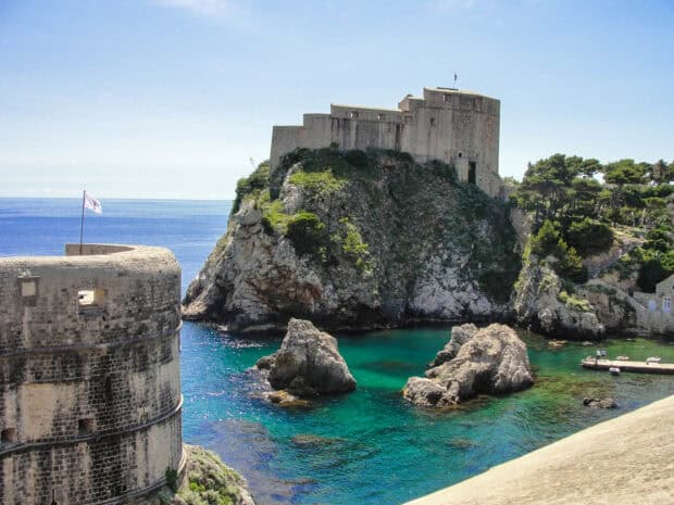 The ancient city walls of Dubrovnik rise above clear blue waters along the Adriatic coast, HD Desktop Wallpaper
