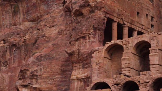 The ancient rock carved structure surrounded by red sandstone cliffs in Petra Jordan captures rich history and desert landscape, 4K Desktop Wallpaper