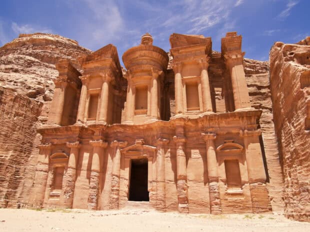 The ancient rock cut architecture at Petra Jordan is shown under a bright blue sky, HD Desktop Wallpaper