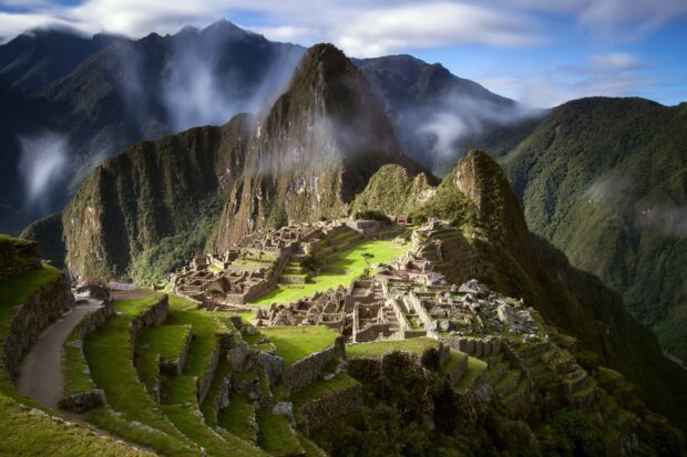 The Peru ruins surrounded by mountains and mist highlight the historical site in the Andes, HD Desktop Wallpaper