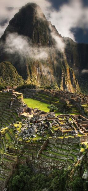 The Peru Wallpapers capture the breathtaking site of ancient terraced ruins beneath a misty mountain, HD Phone Wallpaper