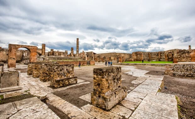 Visitors explore the ancient ruins of Pompeii city under cloudy skies, HD Desktop Wallpaper