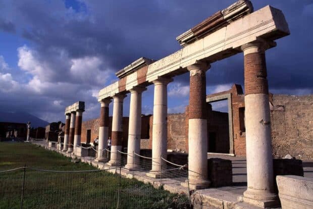 The ancient ruins of Pompeii pillars stand under a blue sky with dramatic clouds, HD Desktop Wallpaper