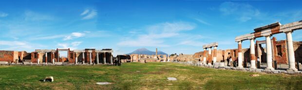 The ancient ruins of Pompeii are set against a clear blue sky with Mount Vesuvius in the background, 4K Desktop Wallpaper
