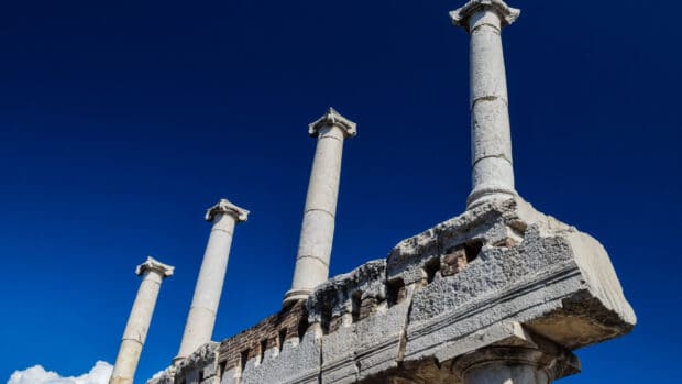 Four ancient columns stand tall in Pompeii against a deep blue sky, 2K Desktop Wallpaper