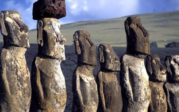 The Easter Island statues stand tall on a grassy hill under a cloudy sky, HD Desktop Wallpaper