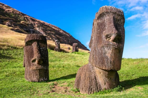 The Easter Island statues stand on a grassy hill under a blue sky, 2K Desktop Wallpaper